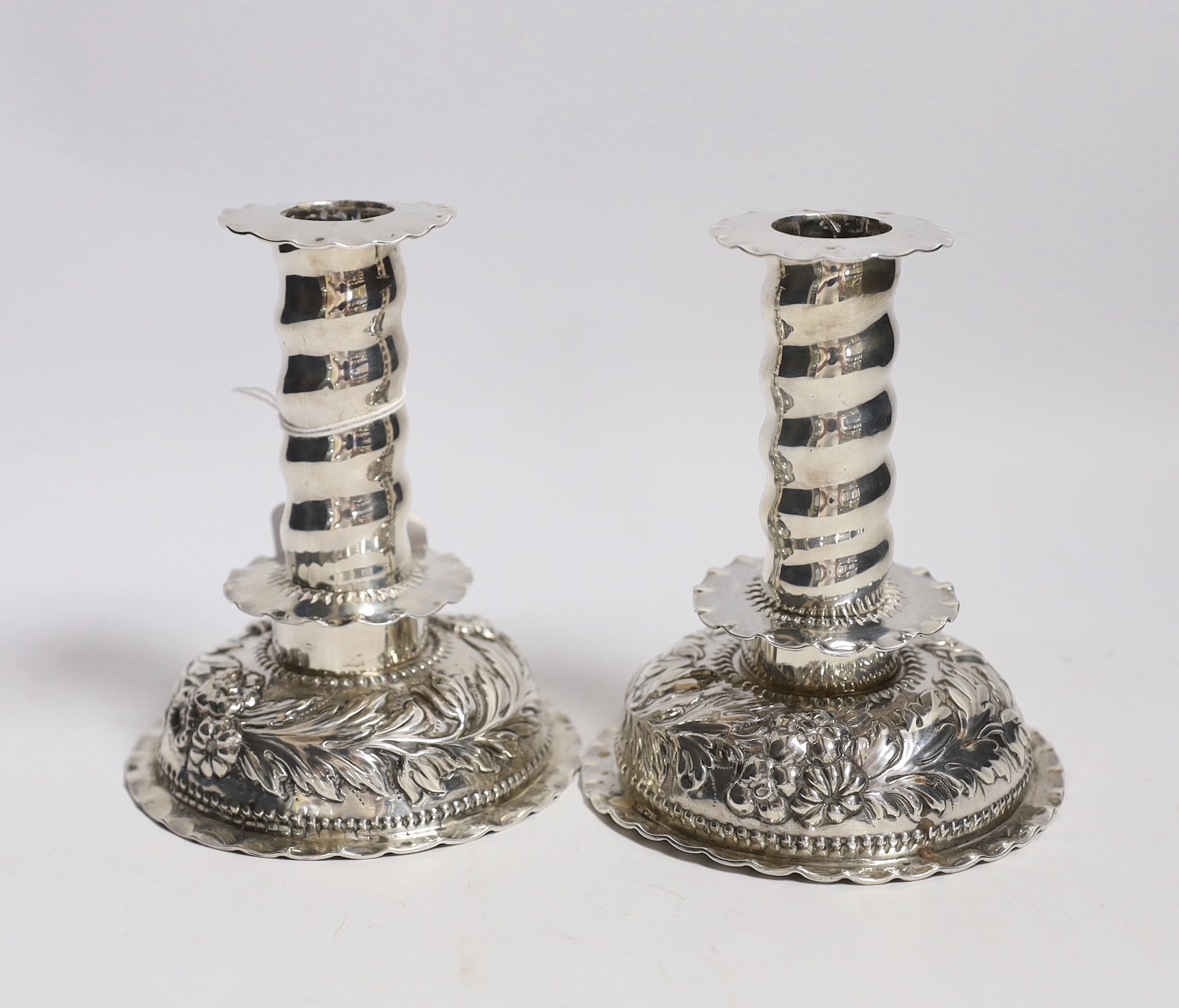 A matched pair of Carolean style silver dwarf candlesticks, London, 1880 & 1885, makers mark on one for George Fox, silver disc to base marked for Charles Stuart Harris, height 12.3cm, weighted.